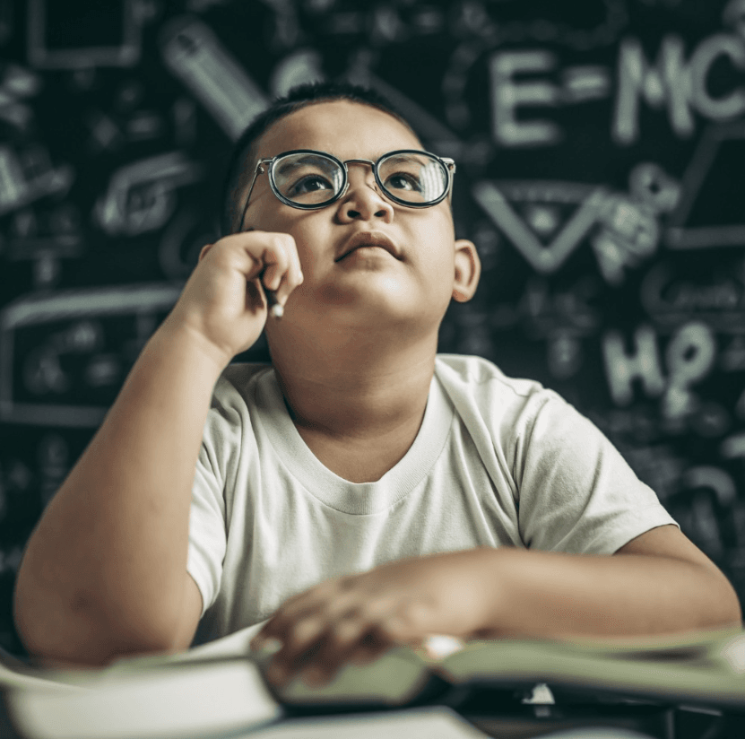 Menino oriental pensando - fundo lousa matemática